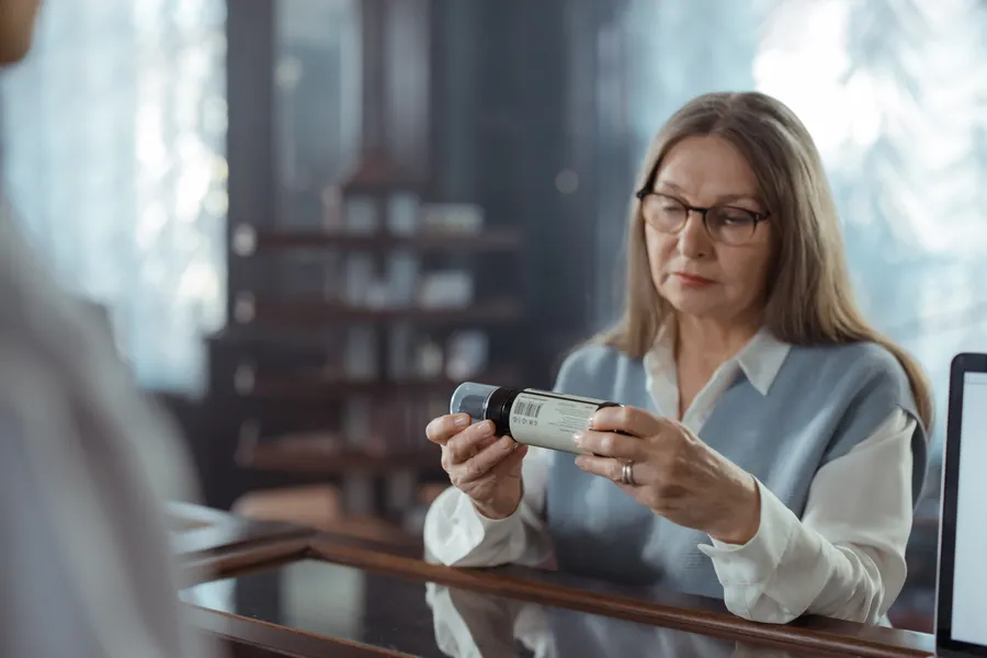 Magnesium Glycinate vs Citrate: Which One Should You Buy? 2 A woman with glasses reads the label on a small bottle