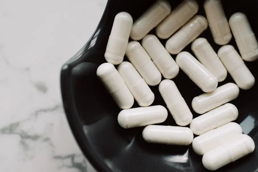 Magnesium Glycinate vs Citrate: Which One Should You Buy? 1 White capsules in a black bowl on a marble surface